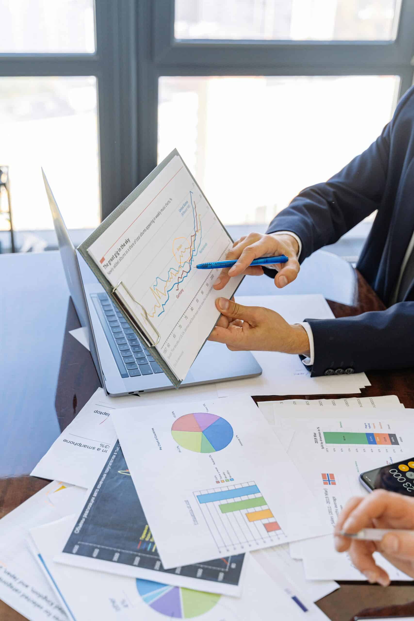 Free Business professionals discussing financial graphs and charts in an office setting. Stock Photo